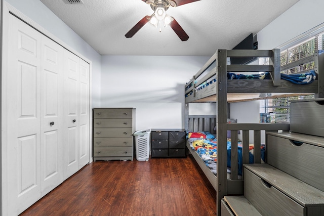 bedroom with a closet, ceiling fan, a textured ceiling, and wood finished floors