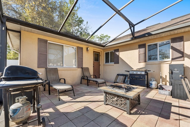 view of patio / terrace featuring an outdoor fire pit, glass enclosure, and area for grilling