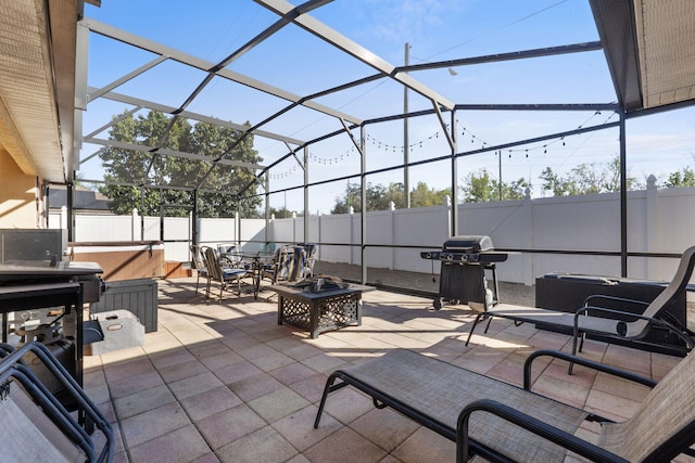 view of patio with a lanai, a fenced backyard, a grill, and a hot tub