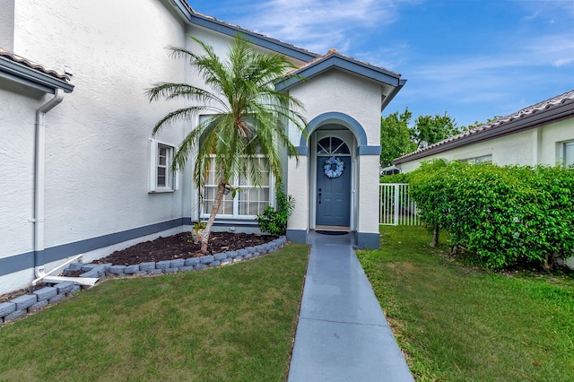 view of exterior entry featuring a yard