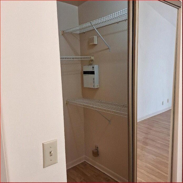 clothes washing area featuring hardwood / wood-style floors