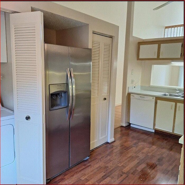 kitchen with dishwasher, washer / clothes dryer, stainless steel fridge with ice dispenser, sink, and white cabinetry