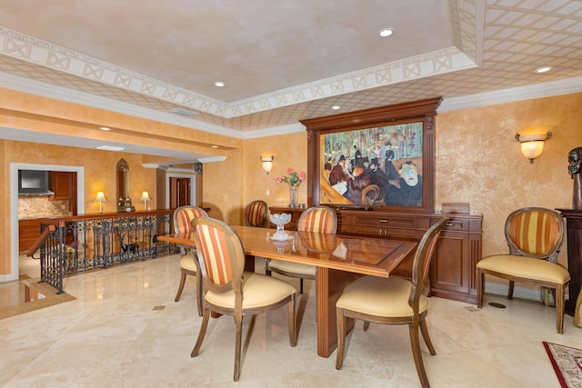 dining room with a raised ceiling and ornamental molding