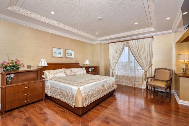 bedroom featuring a tray ceiling, crown molding, and dark wood-type flooring