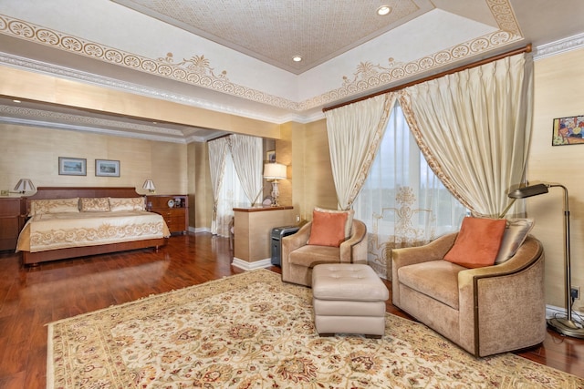 bedroom featuring wood-type flooring, a raised ceiling, and ornamental molding