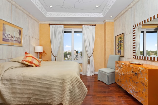 bedroom with ornamental molding, dark wood-type flooring, and a tray ceiling