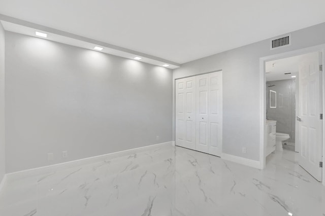 unfurnished bedroom featuring ensuite bath and a closet