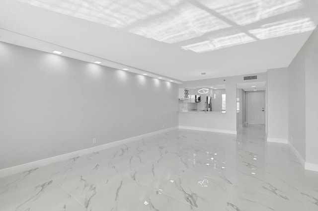 unfurnished room featuring visible vents, baseboards, and marble finish floor