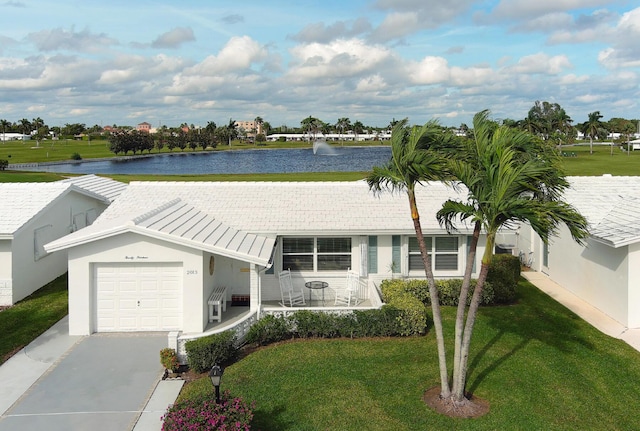 ranch-style home featuring a front yard, a garage, and a water view