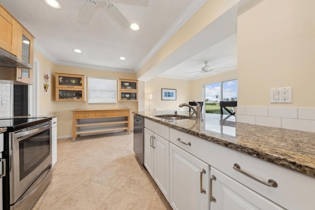 kitchen featuring appliances with stainless steel finishes, white cabinetry, sink, ornamental molding, and stone counters