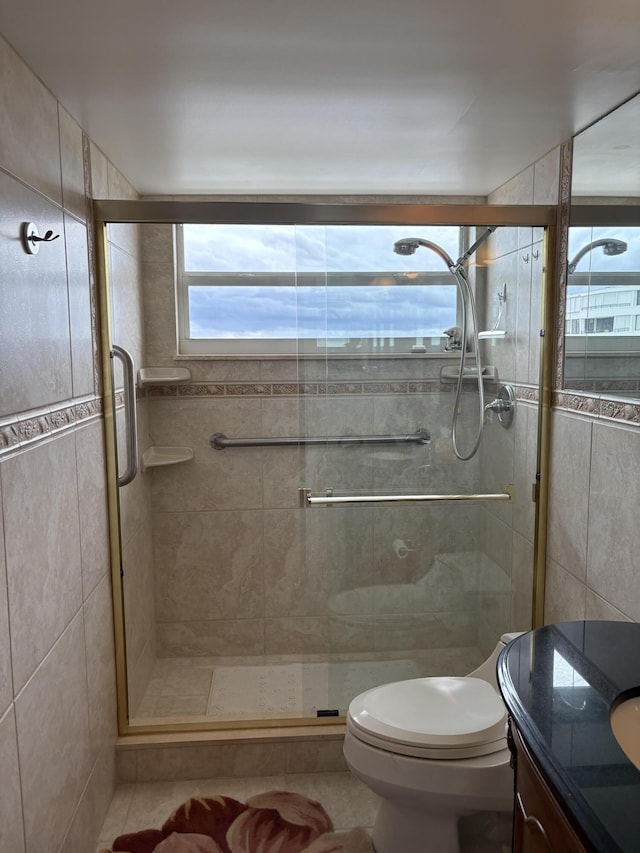 full bathroom with a stall shower, vanity, and toilet