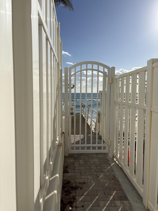 view of gate with a view of the beach and a water view