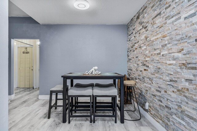 dining room with a textured ceiling and light wood-type flooring