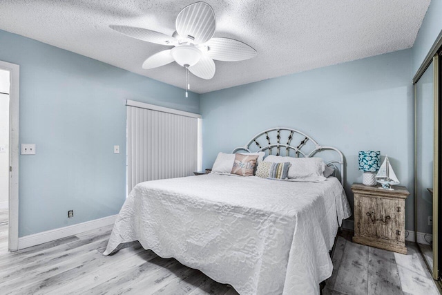 bedroom featuring a textured ceiling, ceiling fan, and light hardwood / wood-style flooring