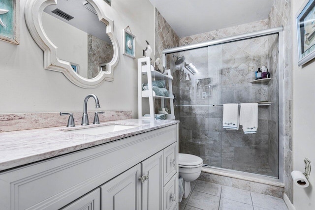 bathroom with toilet, vanity, tile patterned flooring, and a shower with door