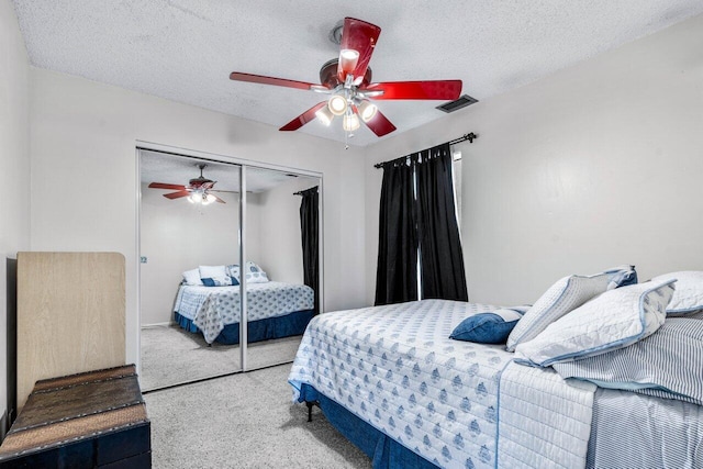 bedroom with a textured ceiling, a closet, carpet floors, and ceiling fan