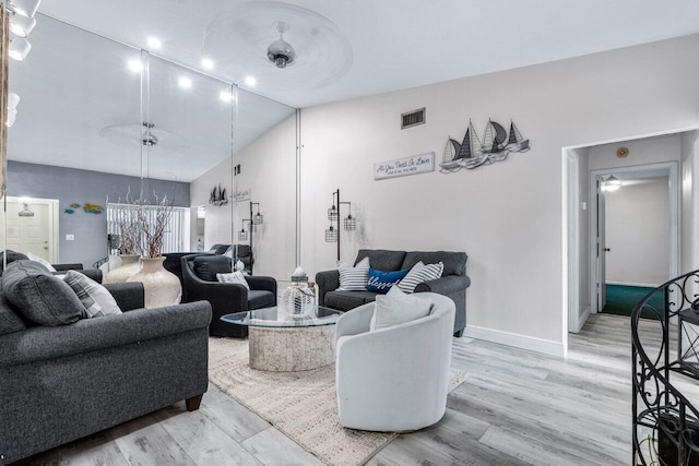 living room with light wood-type flooring and vaulted ceiling