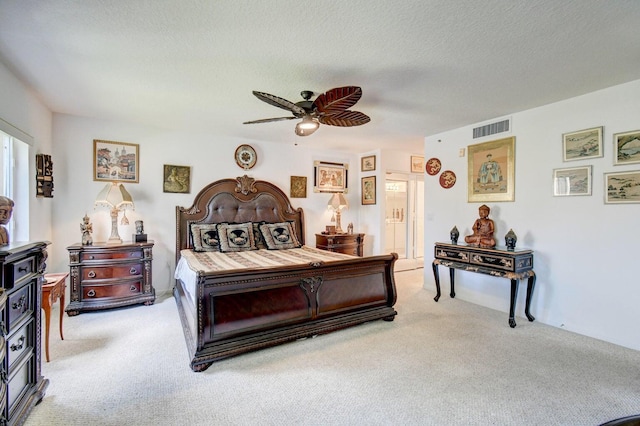 carpeted bedroom featuring a textured ceiling and ceiling fan