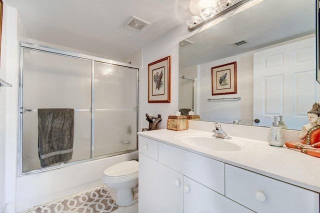 full bathroom featuring toilet, tile patterned floors, vanity, and bath / shower combo with glass door