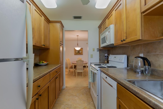 kitchen featuring white appliances, light tile patterned floors, pendant lighting, sink, and backsplash