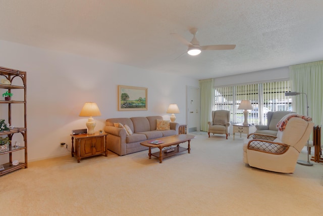 living room with ceiling fan, light colored carpet, and a textured ceiling