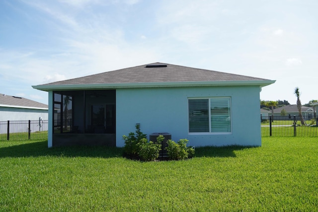 back of property featuring central AC, a yard, and a sunroom