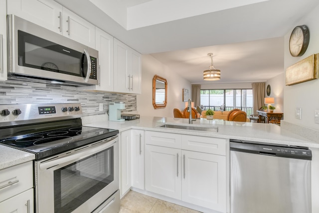 kitchen featuring stainless steel appliances, white cabinets, decorative backsplash, sink, and kitchen peninsula