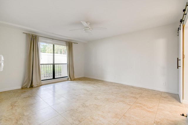 tiled empty room with ceiling fan and a barn door