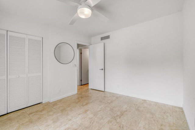 unfurnished bedroom with ceiling fan and a closet