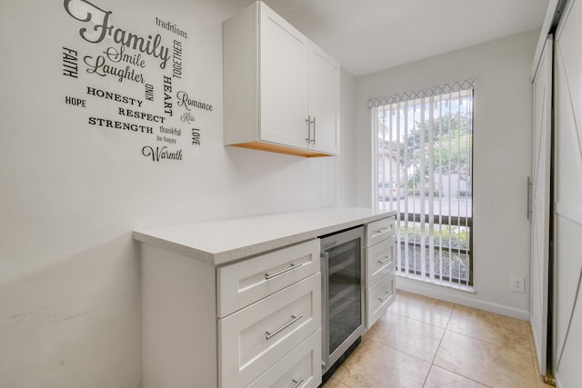 kitchen featuring light tile patterned floors, white cabinets, and wine cooler