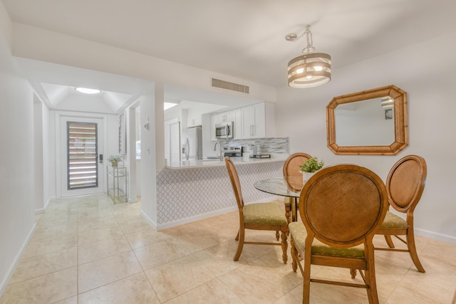 tiled dining area with a chandelier