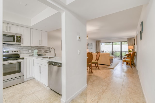 kitchen with tasteful backsplash, sink, white cabinetry, appliances with stainless steel finishes, and light tile patterned floors