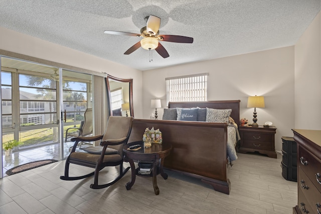 bedroom featuring ceiling fan, access to outside, and a textured ceiling