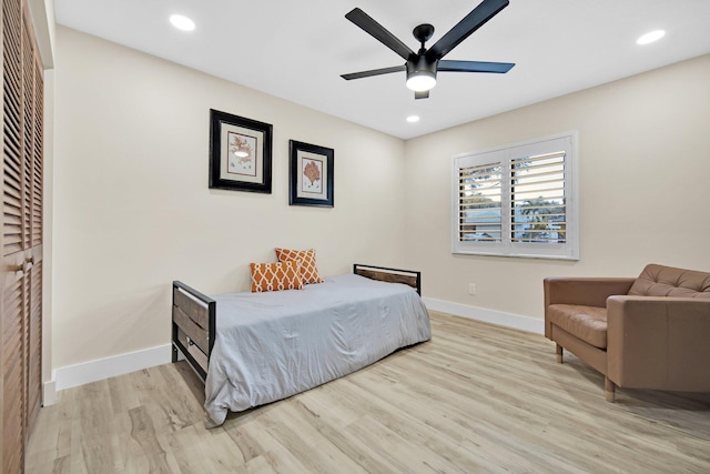 bedroom with ceiling fan, a closet, and light hardwood / wood-style flooring