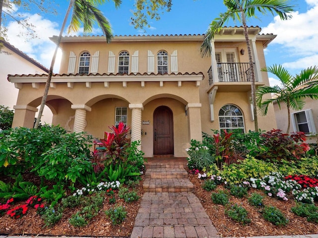 mediterranean / spanish-style house featuring a balcony and stucco siding