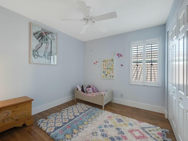 bedroom with ceiling fan, baseboards, dark wood-style flooring, and a closet