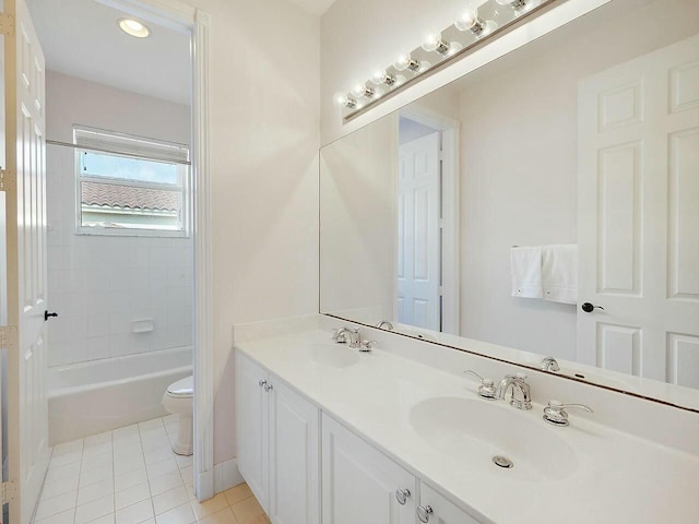 bathroom with double vanity, a sink, toilet, and tile patterned floors