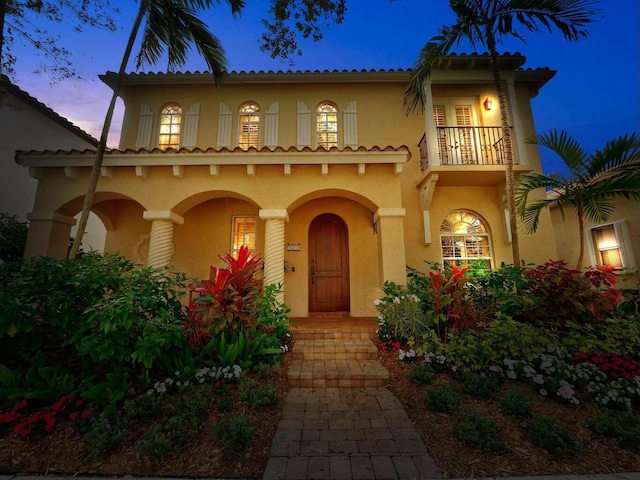 mediterranean / spanish house featuring a balcony and stucco siding