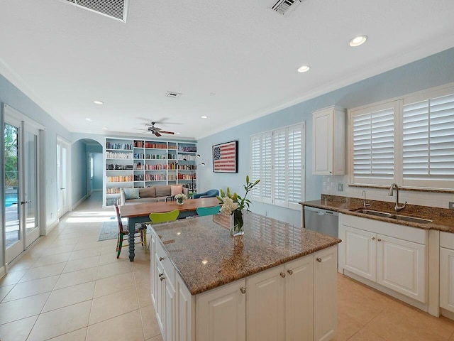 kitchen featuring sink, white cabinetry, dark stone countertops, and a center island