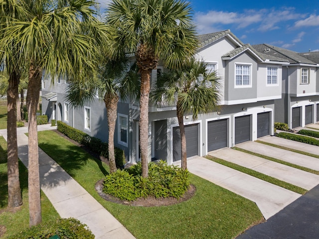 coastal home featuring a front lawn and a garage