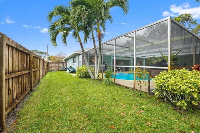 view of yard with a fenced in pool and glass enclosure