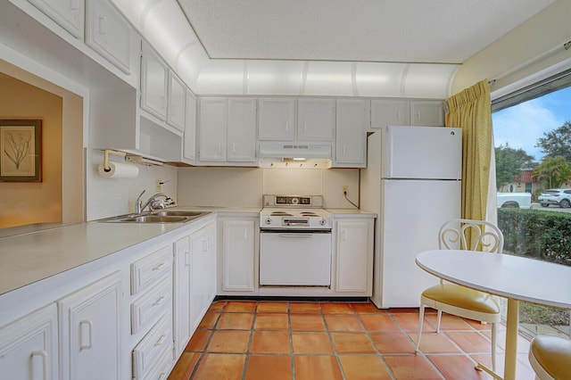 kitchen with sink, white appliances, light tile patterned floors, and white cabinets