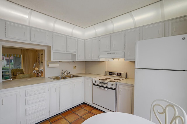 kitchen with sink, tile patterned floors, white appliances, and white cabinetry