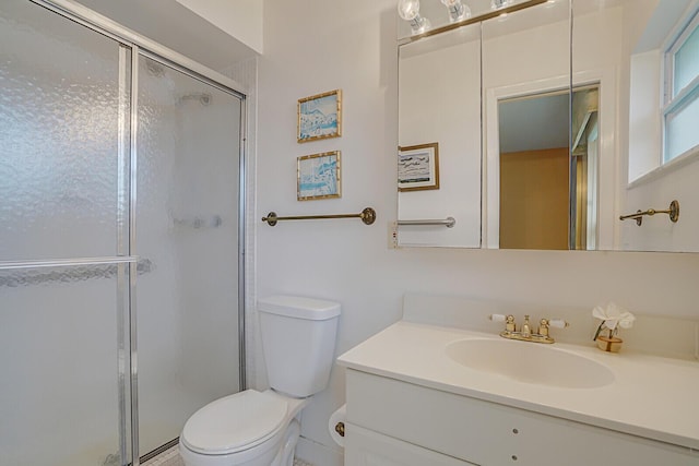 bathroom with toilet, a shower with shower door, and vanity