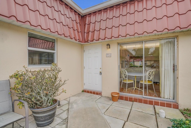 view of exterior entry with a patio area