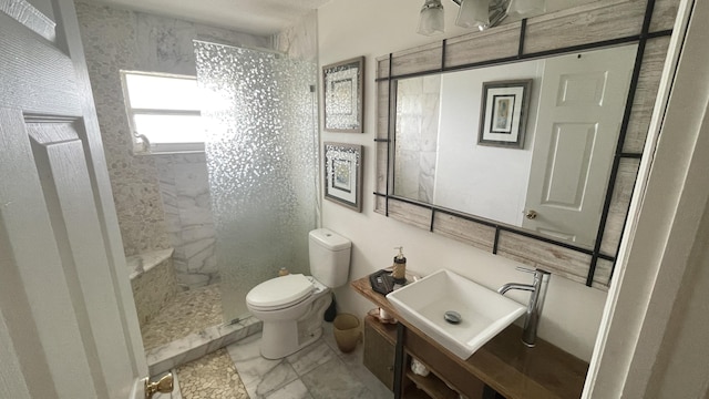 bathroom with toilet, tiled shower, and vanity