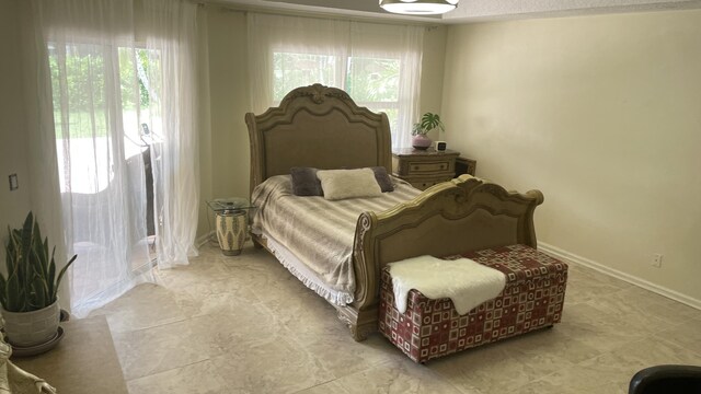 bedroom with a textured ceiling and multiple windows