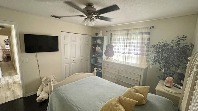 bedroom featuring a textured ceiling, ceiling fan, and a closet