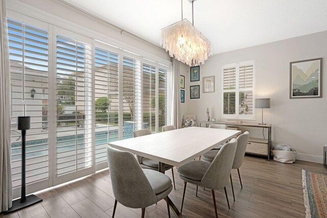 dining area with an inviting chandelier and dark hardwood / wood-style floors