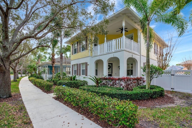 view of front of house with ceiling fan and a balcony